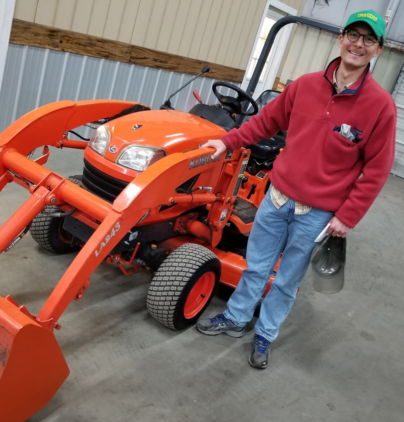 Customor standing near a Kubota tractor